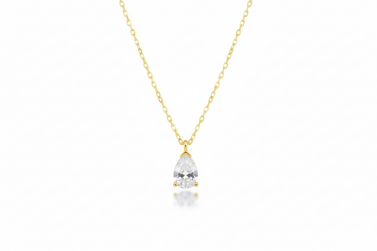 Gold necklace with a teardrop-shaped diamond pendant on a white background