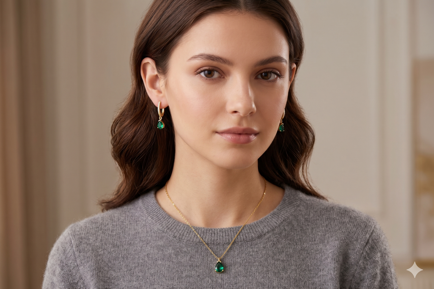 Woman wearing emerald green earrings and necklace against a neutral background