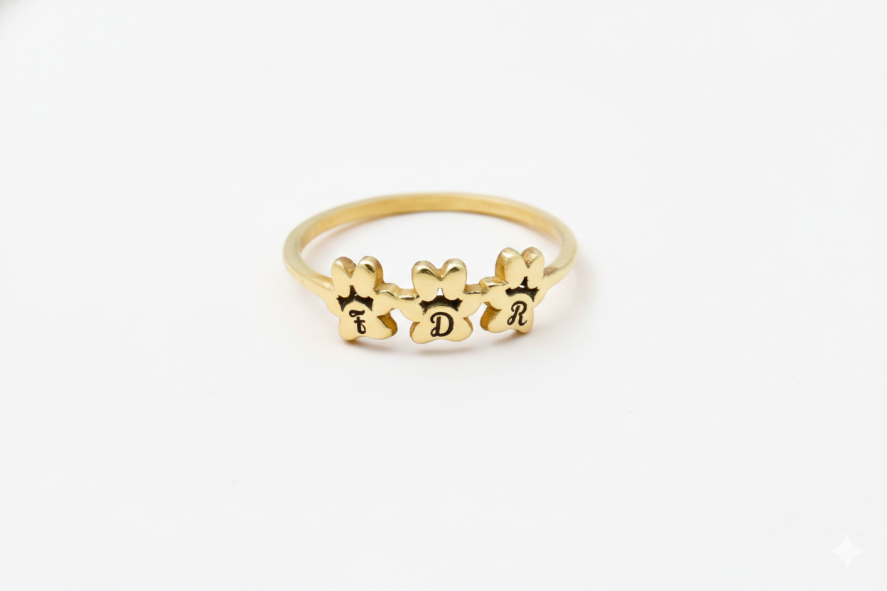 Gold ring with engraved letters on a white background