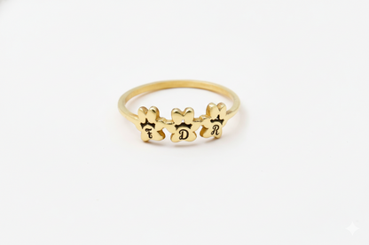 Gold ring with engraved letters on a white background
