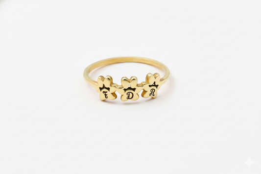 Gold ring with engraved letters on a white background