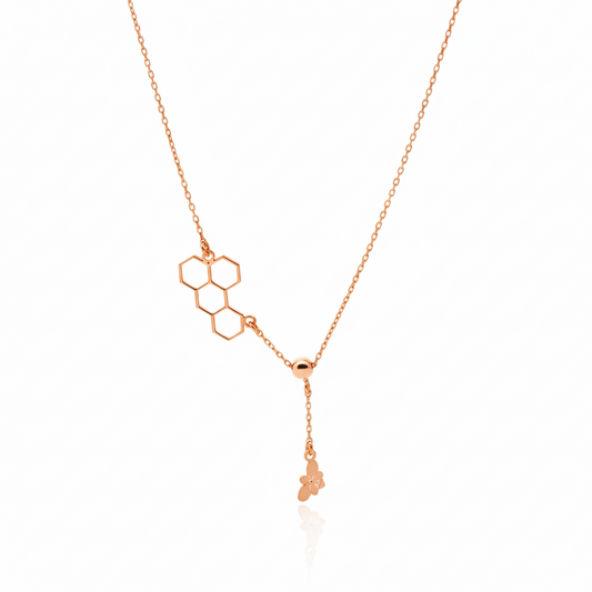 Rose gold necklace with geometric pendant on a white background
