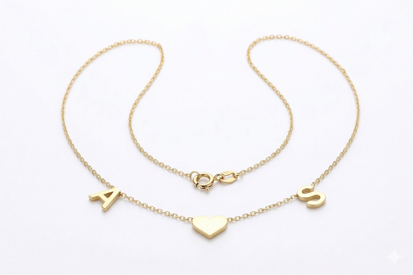 Two gold necklaces with heart and letter pendants on a white background