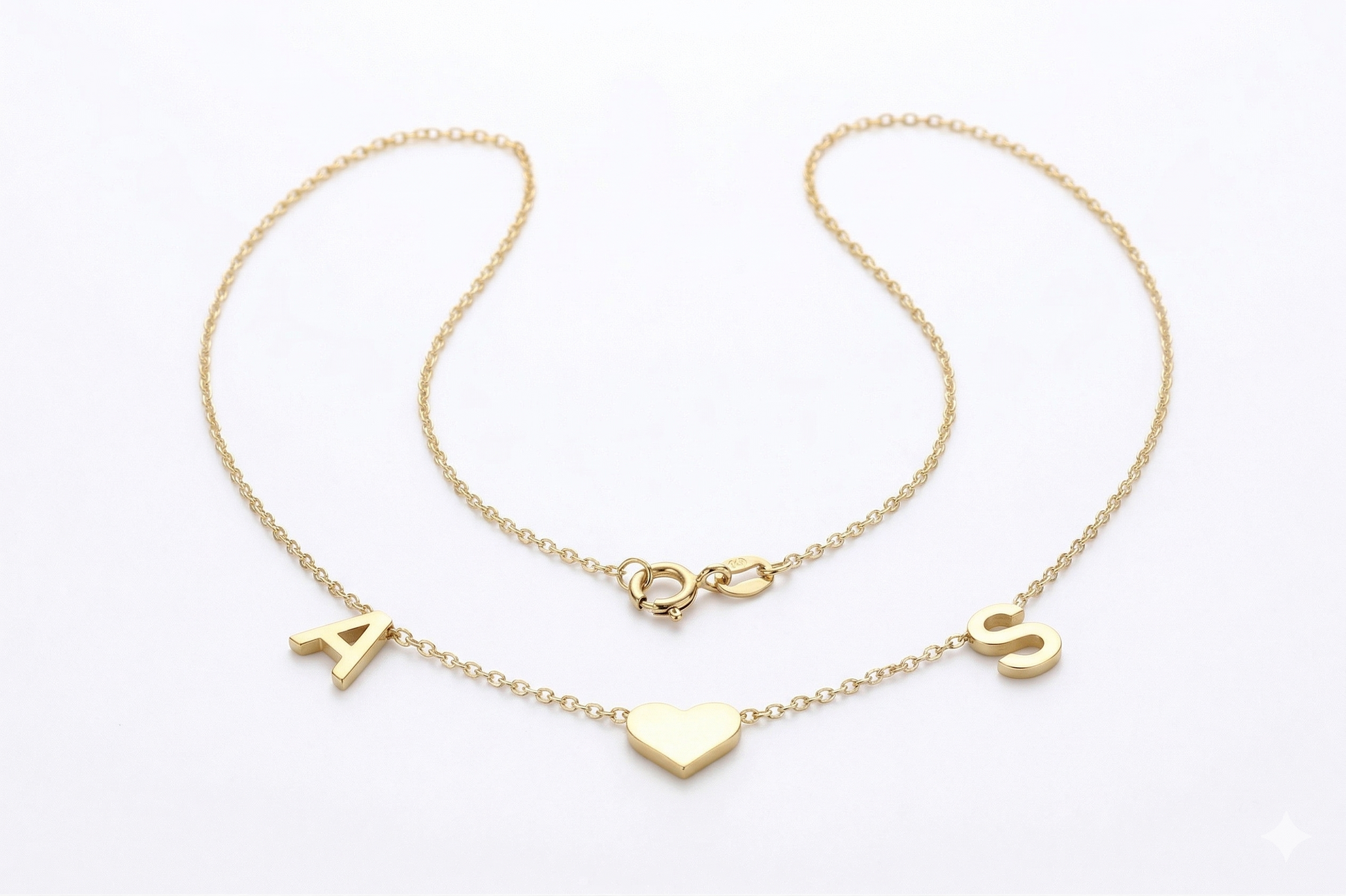 Two gold necklaces with heart and letter pendants on a white background