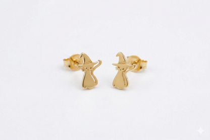 Gold witch earrings on a light gray background