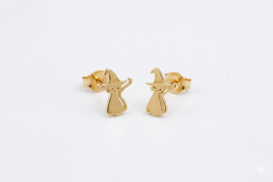 Gold witch earrings on a light gray background