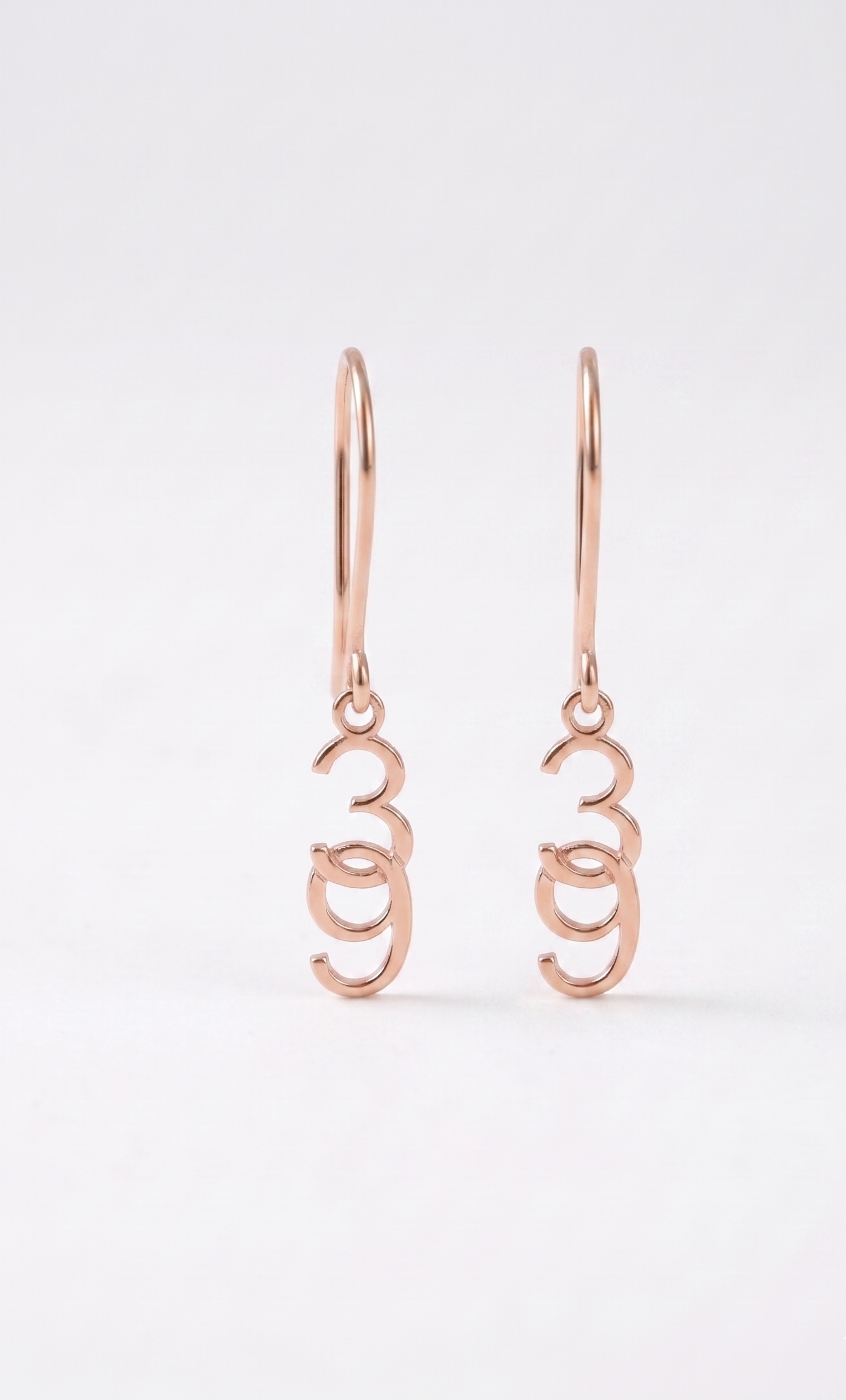 Rose gold earrings on a white background
