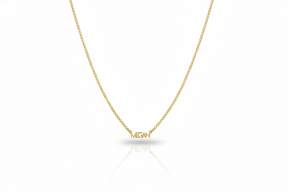 Gold necklace with 'MEGAN' pendant on a white background