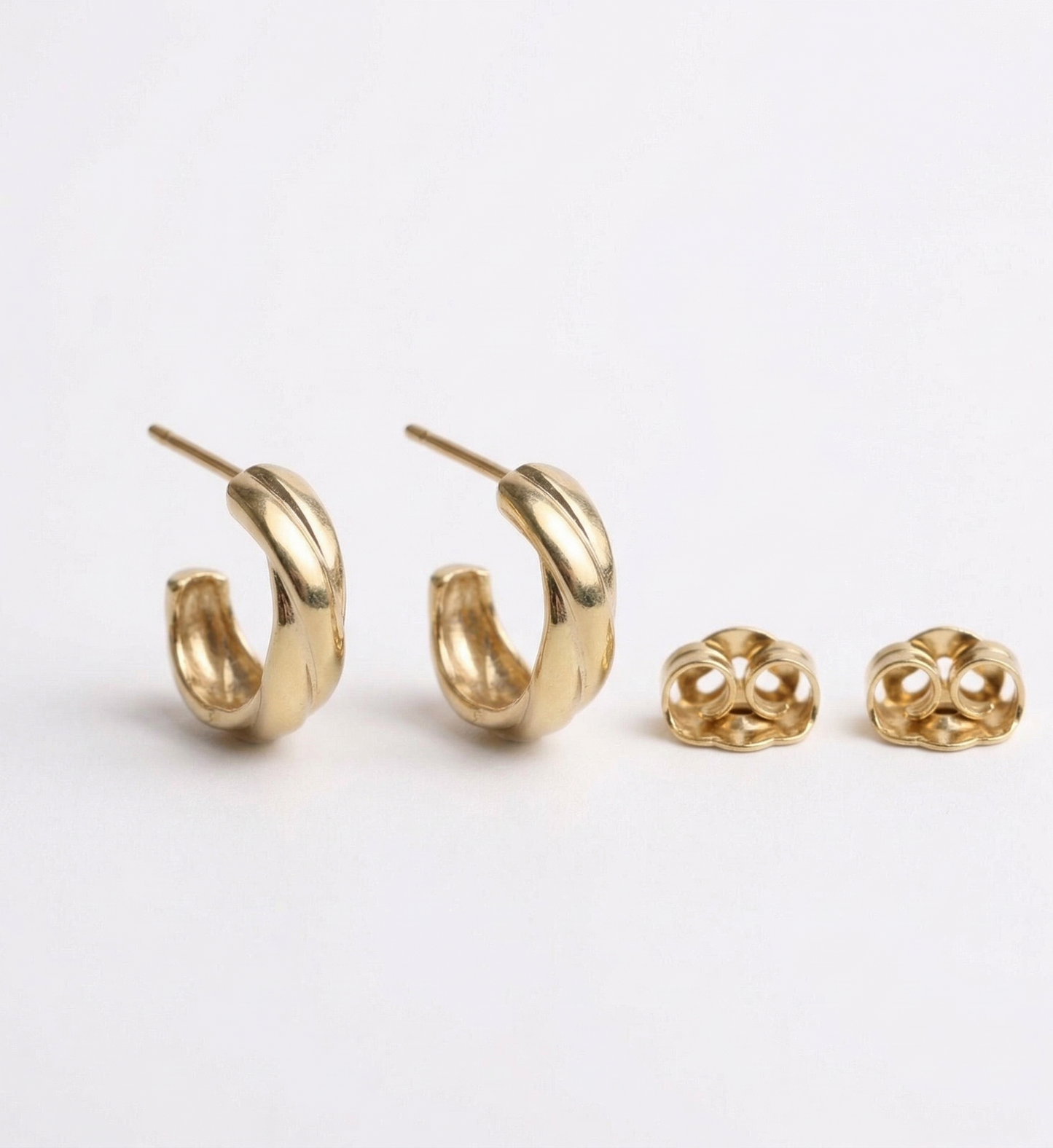 Pair of gold hoop earrings on a light gray background