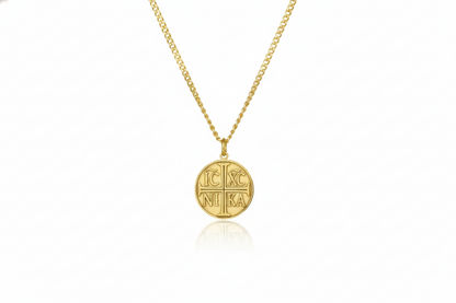 Gold necklace with a round pendant on a white background
