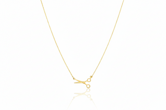 Gold necklace with a small pendant on a white background