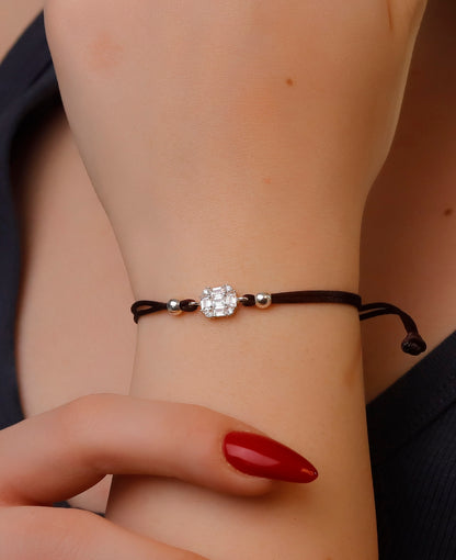 Bracelet with a decorative clasp on a wrist with red nail polish.