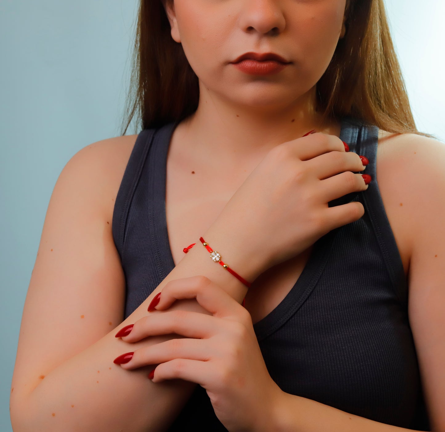 Bracelet with a decorative clasp on a wrist with red nail polish.