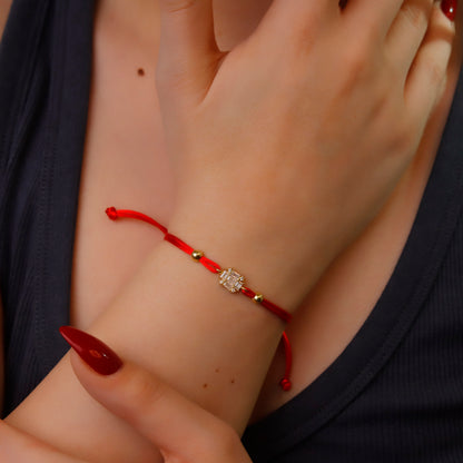 Bracelet with a decorative clasp on a wrist with red nail polish.