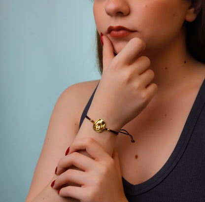 Woman wearing a gold bracelet with a blue background