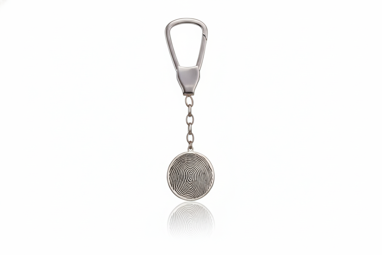 Silver keychain with circular design on a white background