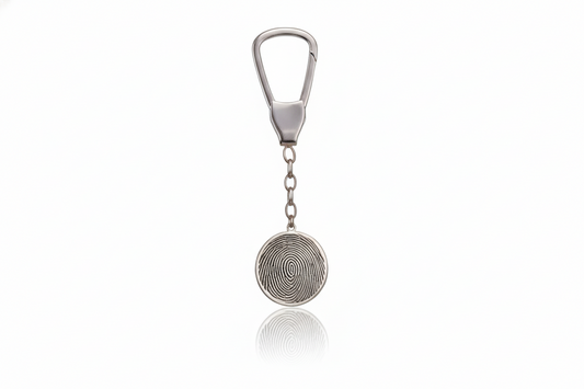 Silver keychain with circular design on a white background