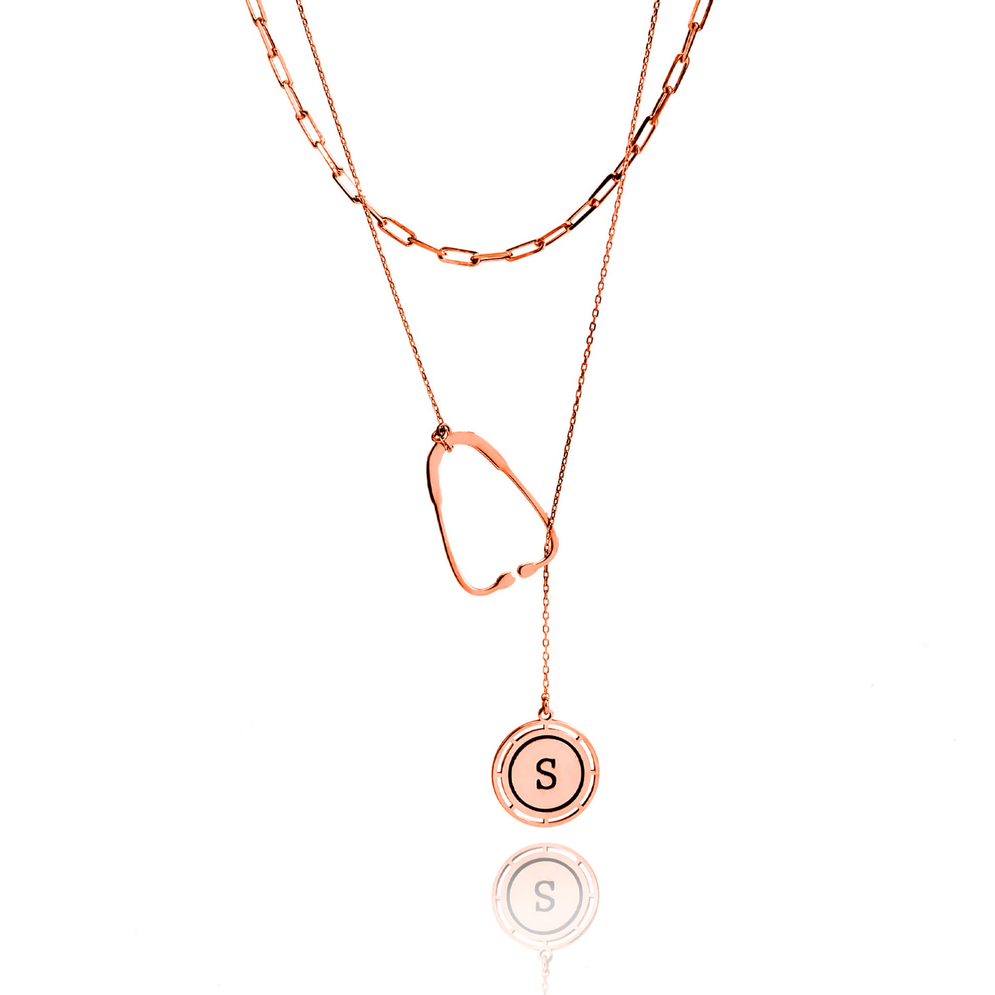 Rose gold necklace with a round pendant featuring the letter 'S' on a white background