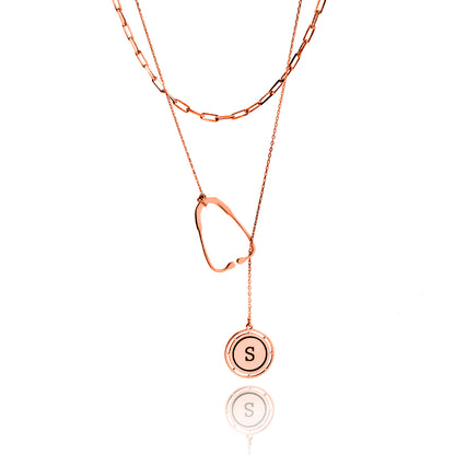Rose gold necklace with a round pendant featuring the letter 'S' on a white background