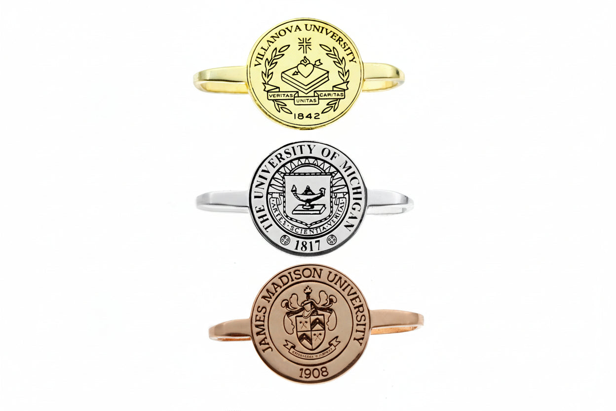 Three university-themed rings in gold, silver, and rose gold on a white background.