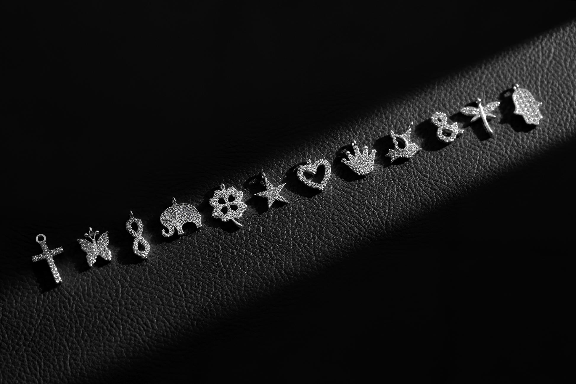 Collection of silver earrings on a dark textured surface