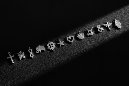 Collection of silver earrings on a dark textured surface