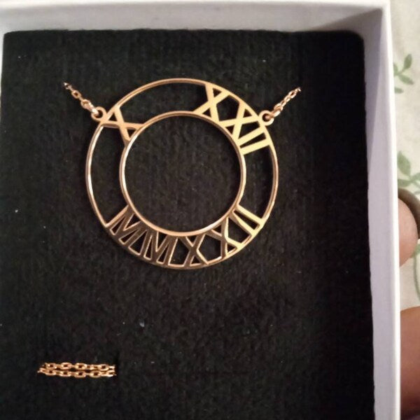 Rose gold geometric hoop necklace on a black background