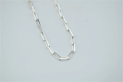 A close-up image of a silver loop chain necklace with a delicate and dainty design.