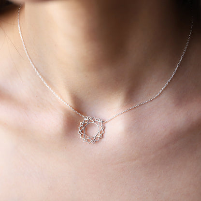 a silver-colored choker necklace with a geometric design, representing the Sahasrara Yoga chakra.