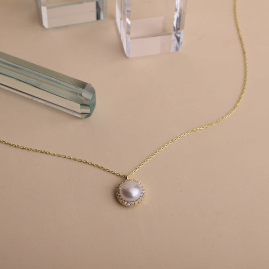  a dainty pearl necklace with a pearl drop pendant, gold chain, and round pearl jewelry.