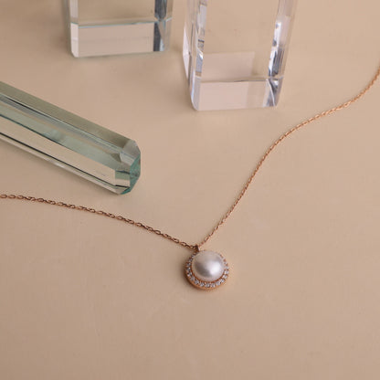 a dainty pearl necklace with a pearl drop pendant, gold chain, and round pearl jewelry.
