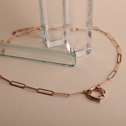 a rose gold link chain necklace with a paperclip-shaped pendant and Sailor Lock.