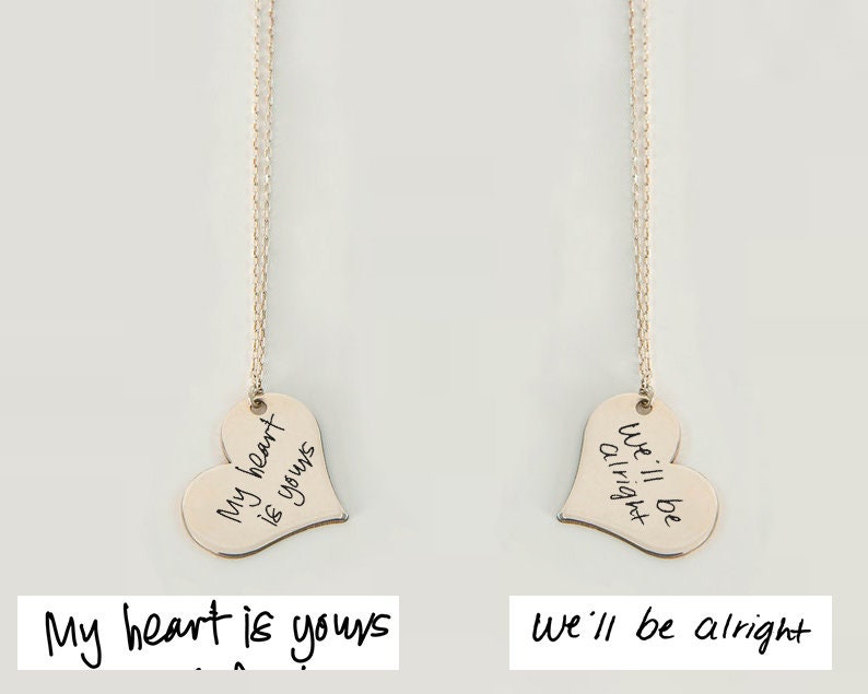 Two heart-shaped pendants on necklaces with engraved phrases on a light gray background.
