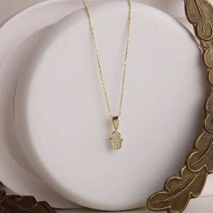 A gold-colored Hamsa Charm Necklace with a Hand of Fatima design and pave CZ diamonds.