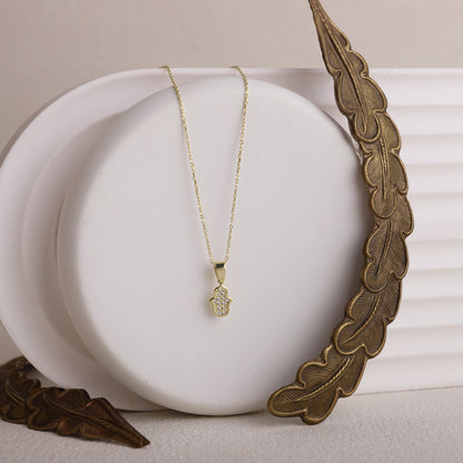 A gold-colored Hamsa Charm Necklace with a Hand of Fatima design and pave CZ diamonds.
