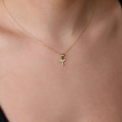 A close-up image of a woman wearing a gold-filled dragonfly necklace with a dainty pendant.