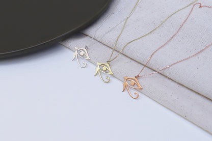 Eye of Ra necklace displayed on a white back ground, featuring a dainty pendant with intricate details.