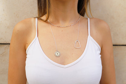 on https://silvergoldandrose.com/ . A person wearing a white tank top showcasing a silver necklace with a stethoscope charm. Pulse Heart Stethoscope Necklace - Elegant Design Celebrating Healthcare Heroes