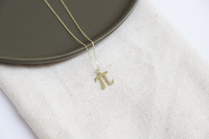 a dainty pendant necklace with the Pi symbol, in a gold-tone finish.