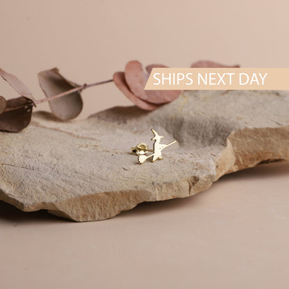 A close-up image of aa small gold stud earring with a witch design