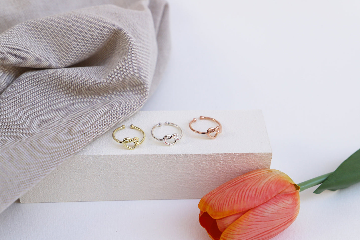 Gold rings on a box with a tulip flower on a white background