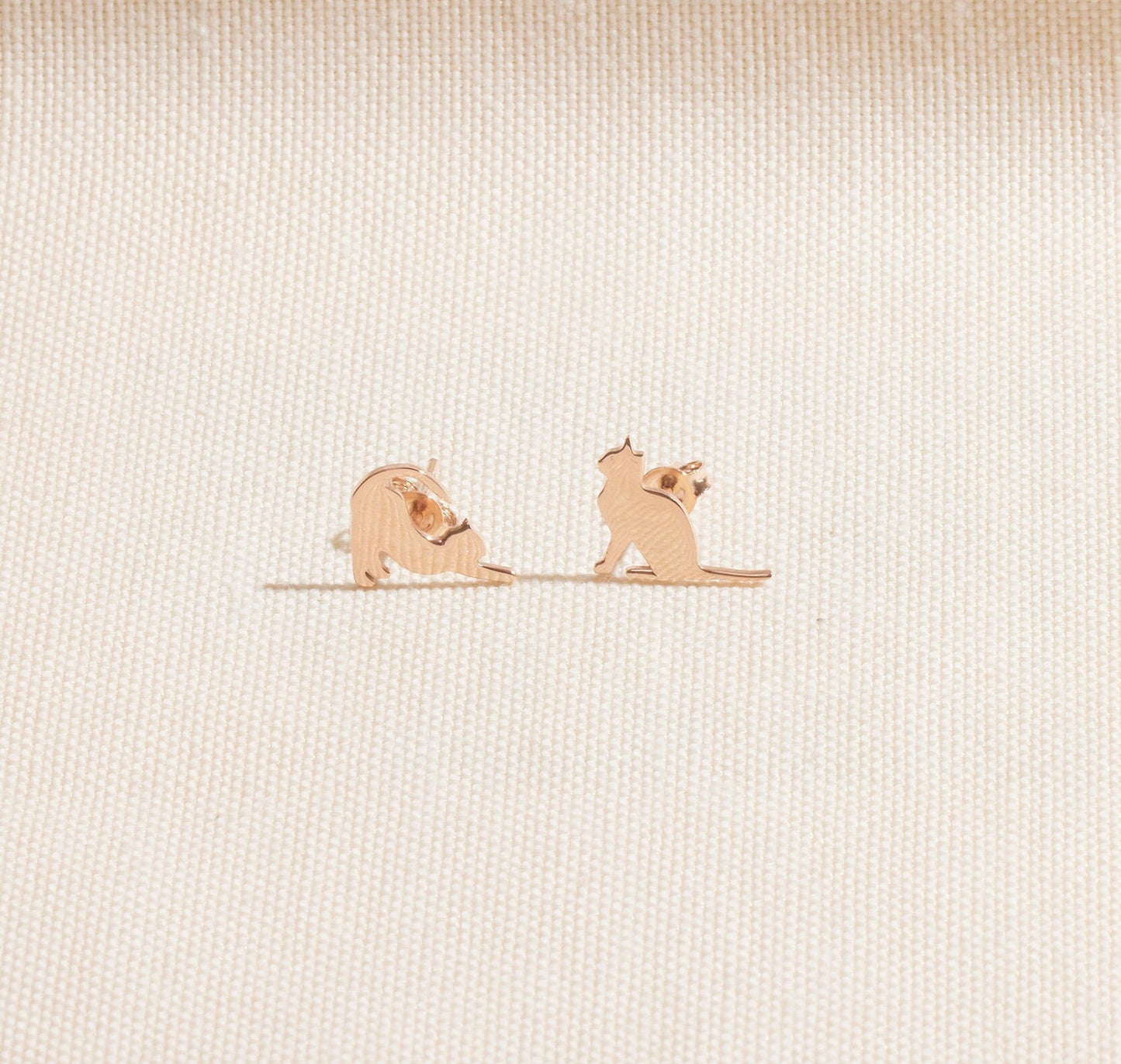 Two small dog figurines on a textured beige surface