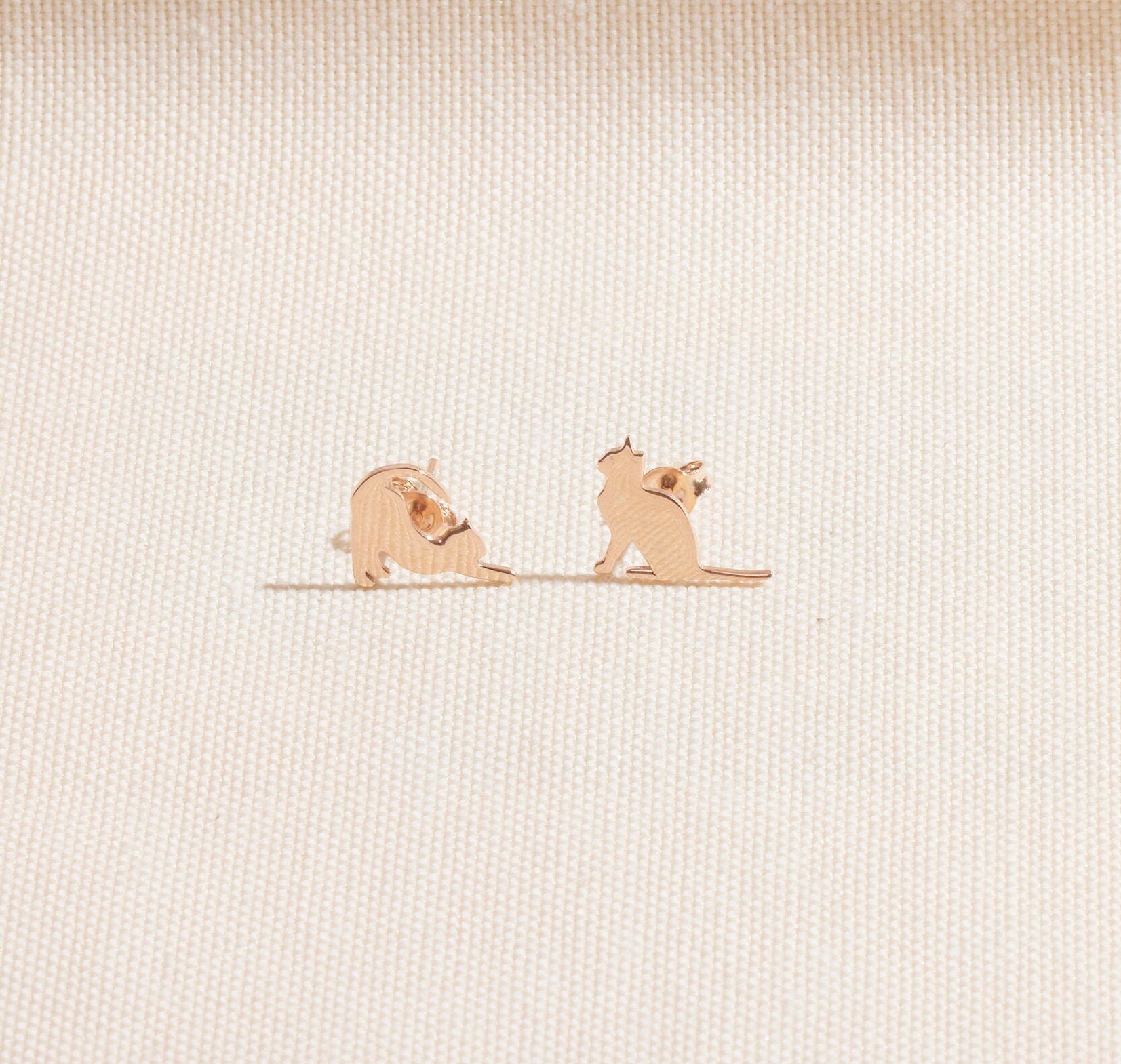 Two small dog figurines on a textured beige surface