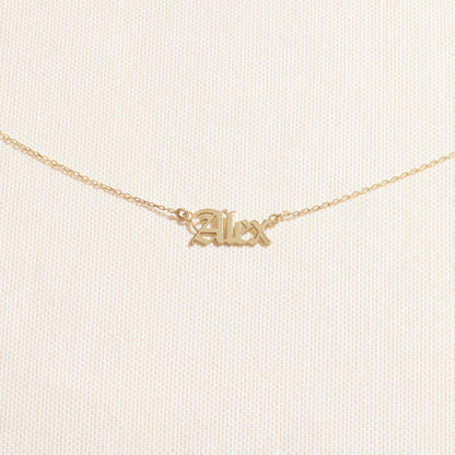 Gold 'Alex' necklace on a light beige background
