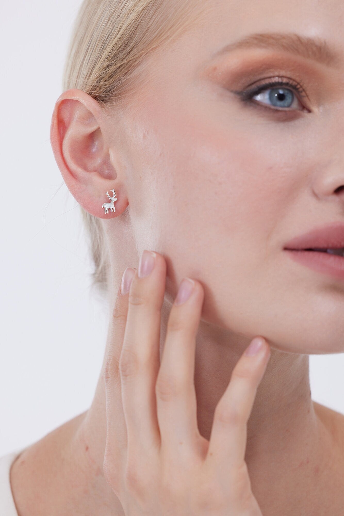 Close-up of a woman wearing a silver earring with a small star design.