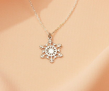 Silver snowflake necklace on a beige background