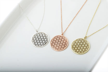 Three gold necklaces with geometric pendants on a white background
