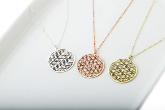 Three gold necklaces with geometric pendants on a white background