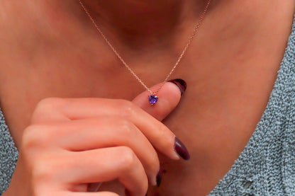A woman wearing a delicate pink quartz, ametrine, and amethyst crystal choker necklace in silver tone.
