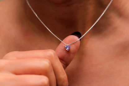 A woman wearing a delicate pink quartz, ametrine, and amethyst crystal choker necklace in silver tone.